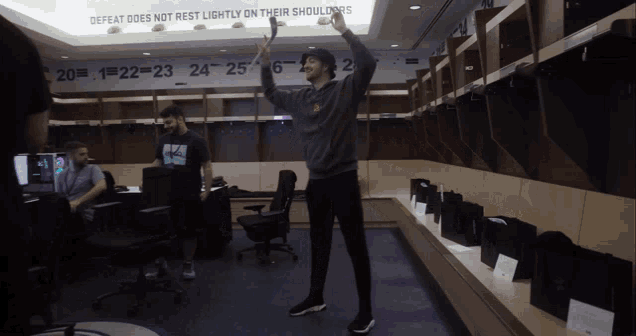 a man in a locker room with a sign that says defeat does not rest lightly on their shoulders on the ceiling