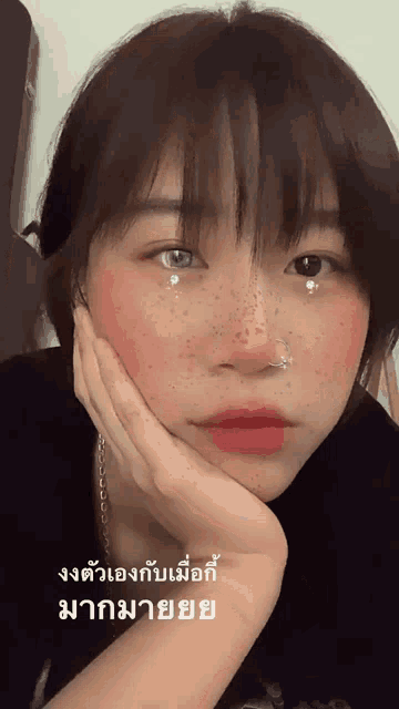 a girl with freckles on her face is looking at the camera