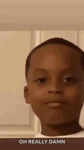 a young boy is making a funny face while looking at the camera and saying `` oh really damn '' .