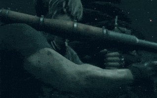 a man is holding a rocket launcher that is shooting flames
