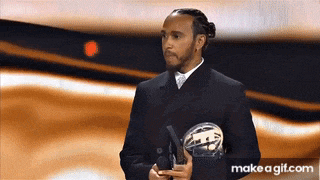 a man in a suit is holding a trophy on a stage