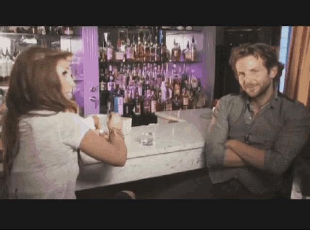 a man and woman are sitting at a bar talking