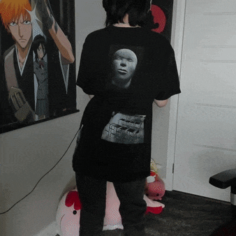 a person wearing a black t-shirt with a picture of a face on the back