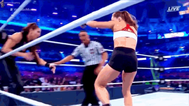 two women are wrestling in a ring with the words live on the bottom right