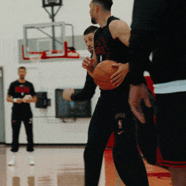 a man holding a basketball with the word bulls on his knee
