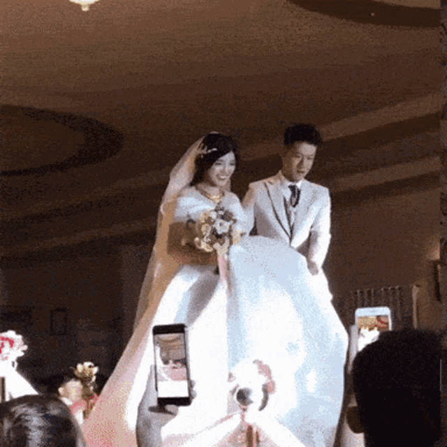 a man is taking a picture of a bride and groom at their wedding