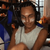 a man wearing headphones and glasses is sitting in a chair and smiling .
