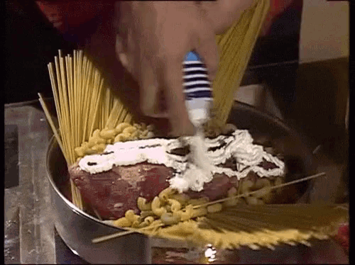a person is putting spaghetti into a pot with meat and beans