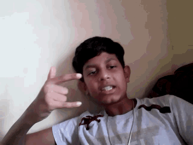 a boy wearing a shirt that says ' abercrombie & fitch ' on it is giving the middle finger