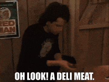 two men are sitting at a table with the words oh look a deli meat written on the screen