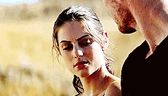 a man and a woman are standing next to each other and looking at each other .