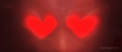 a close up of a person 's eyes with two red hearts in them .