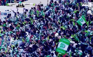 a crowd of people are gathered in a stadium with a sign that says " pro "
