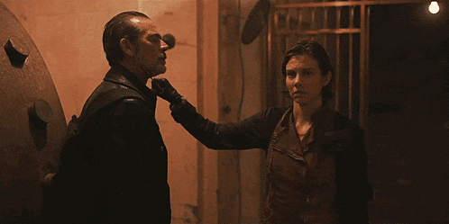 a man and a woman are standing next to each other and the woman is touching the man 's neck
