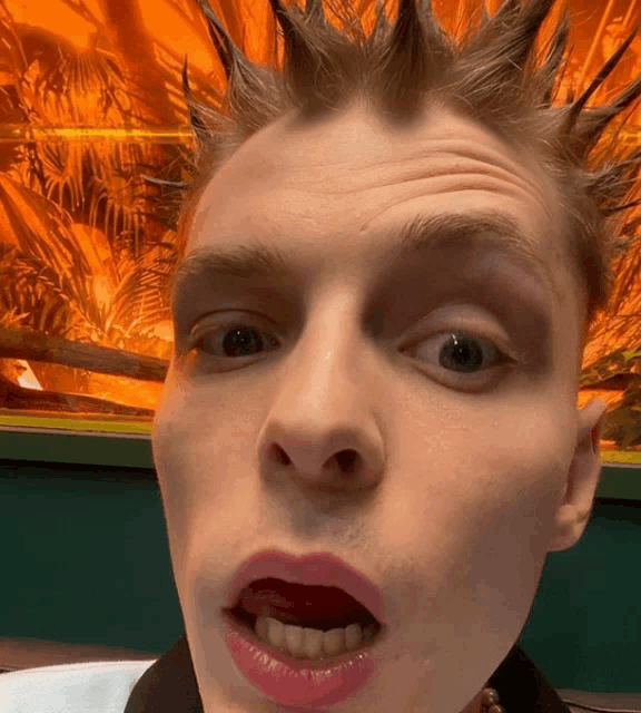 a close up of a man 's face with his mouth open and red lips