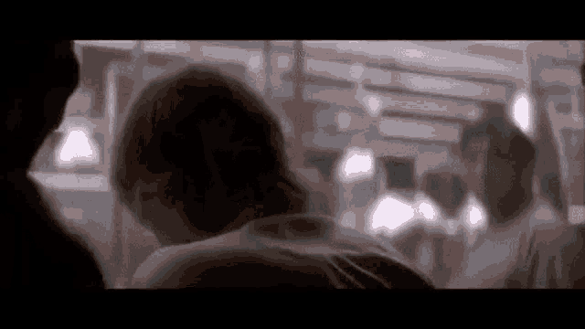 a man is sitting in a dark room with a group of people .