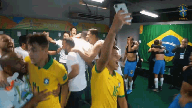 a group of soccer players are taking a selfie in a changing room