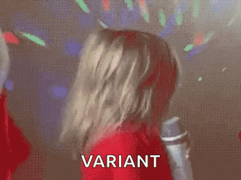 a little girl in a red sweater is holding a remote control and making a face .
