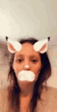 a woman wearing a cat mask with ears and a white mouth .
