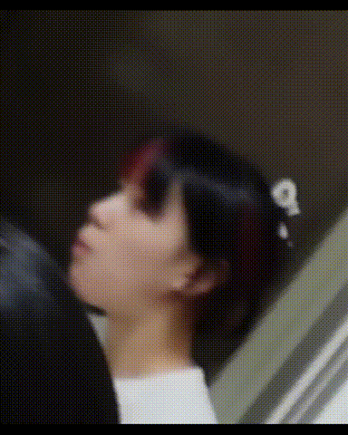 a woman with red hair and a flower in her hair is looking down .