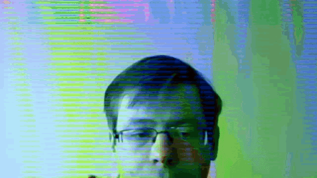 a man wearing glasses and headphones is standing in front of a colorful background .
