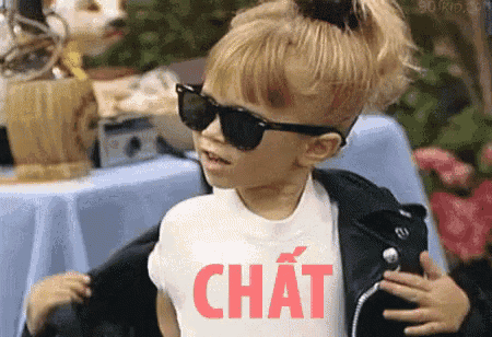a little girl wearing sunglasses and a shirt that says chat on it