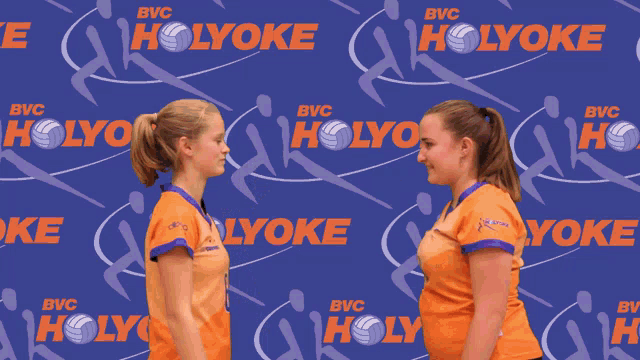 two girls hugging each other in front of a blue background that says holyoke