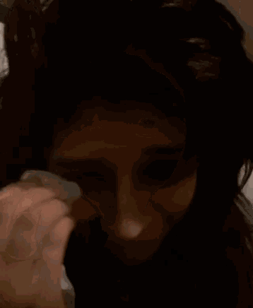 a woman is crying while holding a tissue to her face