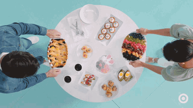 two people sitting at a table with plates of food and a target logo in the background