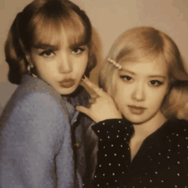 two women are posing for a picture and one has a pearl in her hair