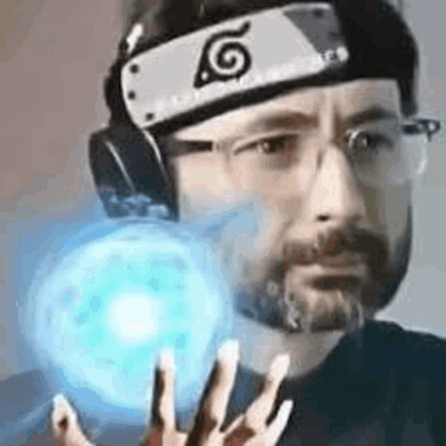 a man with a beard and glasses is wearing a headband and headphones and holding a blue ball .