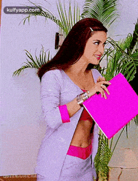 a woman is holding a pink folder in her hand and smiling .