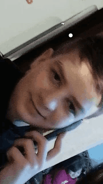 a blurry picture of a boy talking on a cellphone