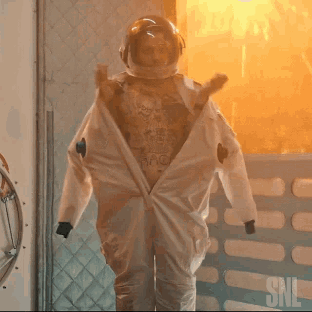 a man in a space suit stands in front of a snl logo