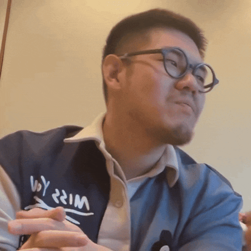 a man wearing glasses and a shirt that says ' voy ' on it
