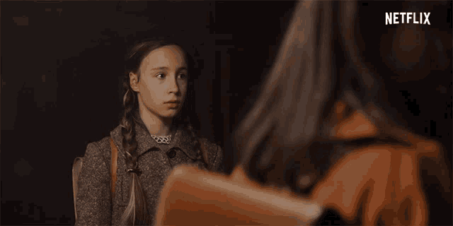 a netflix ad shows a girl with braids looking at another girl