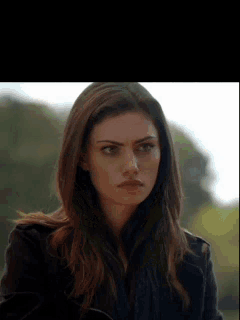 a close up of a woman 's face with a serious expression .