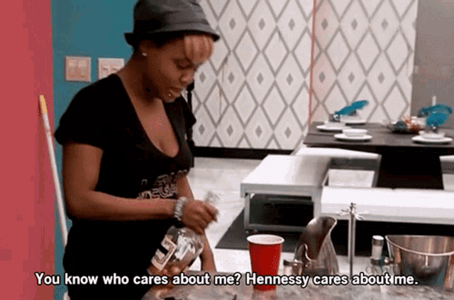 a woman is holding a bottle of hennessy and says " you know who cares about me hennessy cares about me "