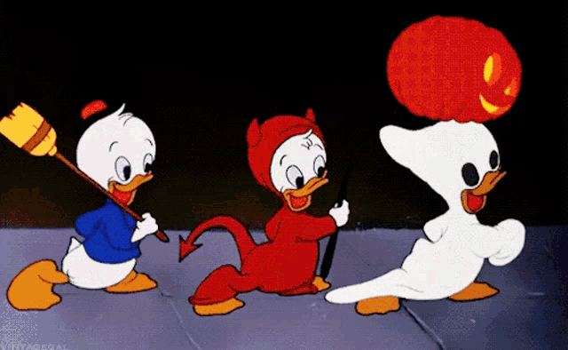three cartoon ducks dressed up in halloween costumes