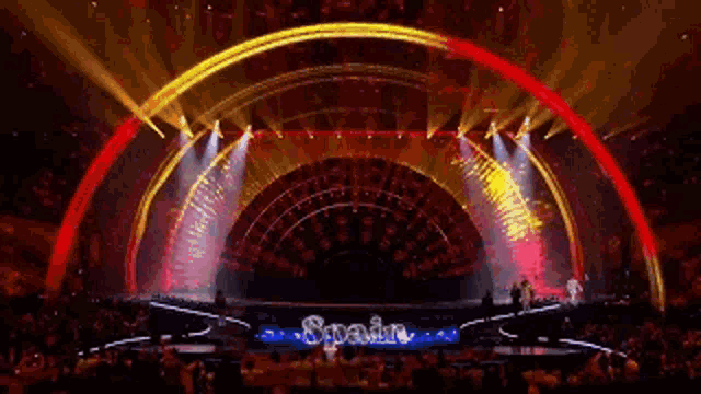 the word spain is on the stage in front of a crowd of people