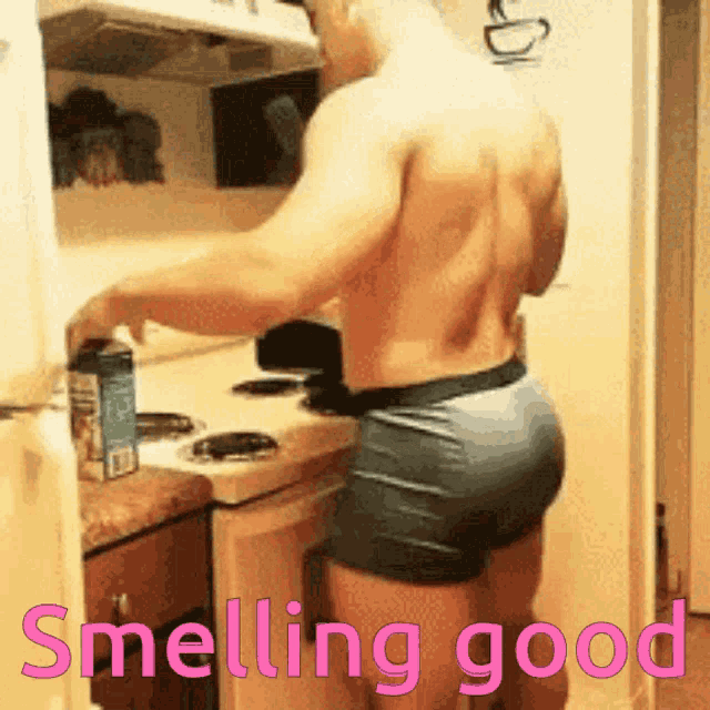 a shirtless man in shorts is standing in a kitchen with the words smelling good above him