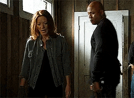 a man and a woman are standing next to each other in a room next to a door .