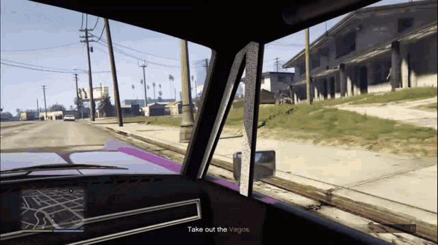 a purple car is driving down a street and says take out the vagos