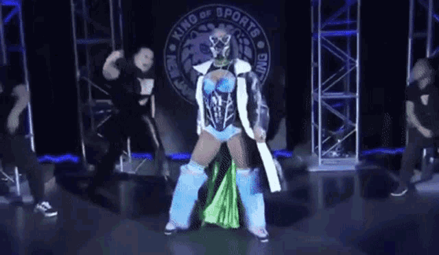 a woman in a blue and green outfit is standing in front of a banner that says king of sports
