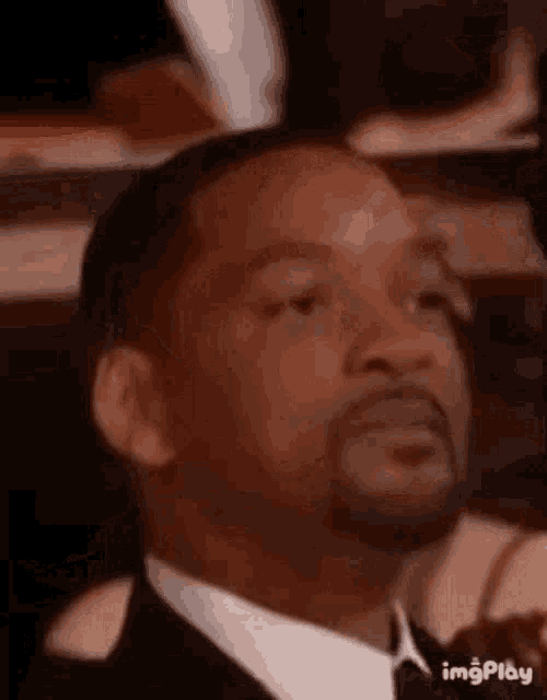 a man in a suit and tie is sitting in a chair .
