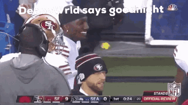 a football player wearing a 49ers helmet stands on the sidelines