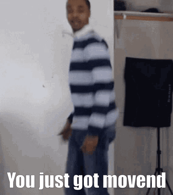 a man in a striped shirt is standing in a room with the words you just got movend written on the bottom