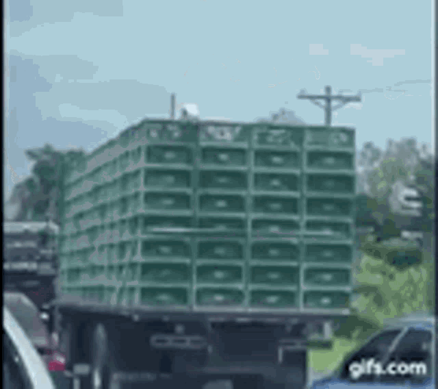 a truck with a lot of speakers on the back of it is driving down the road .