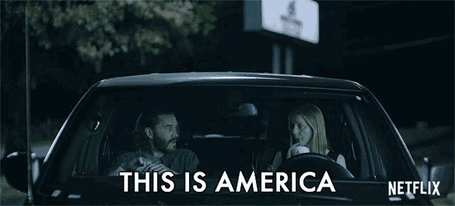 a man and a woman are sitting in a car that says this is america on it