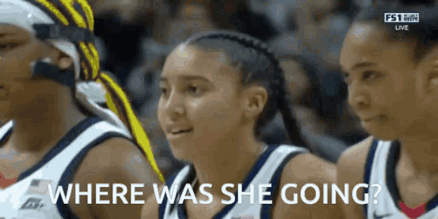 a group of female basketball players are watching a game and one of them is asking where was she going